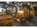 Wooden chairs overlooking tranquil marsh at sunset at 122 Cainhoy Landing Rd, Charleston, SC 29492