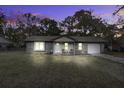 Brick ranch house with attached garage, illuminated at night at 208 Janice St, Goose Creek, SC 29445