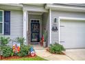 Front entry with door, welcome sign, and potted plants at 119 Osage Way, Summerville, SC 29483