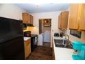 Galley kitchen with black appliances and wood cabinets at 1905 Central Park Rd # B, Charleston, SC 29412