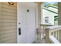 White front door with keypad entry and small bench at 6231 Rolling Fork Rd # H 1208, North Charleston, SC 29406