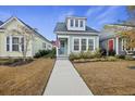 Quaint two-story home with light gray siding and a charming front porch at 658 Blueway Ave, Summerville, SC 29486