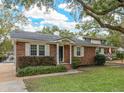 Ranch style brick home with landscaping and a large tree at 1432 River Front Dr, Charleston, SC 29407