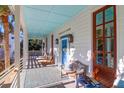 Relaxing front porch with wooden furniture and blue ceiling at 2514 Myrtle Ave, Sullivans Island, SC 29482