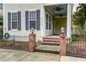 Brick steps leading to a covered porch with a ceiling fan and lamps at 312 White Gables Dr, Summerville, SC 29483