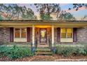 Front entrance with glass door, brick facade, and burgundy shutters at 7 Andrea Ct, Hanahan, SC 29410