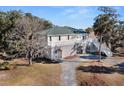 Elevated view of a two-story home with a metal roof and wrap around porch at 9681 Two Pines Rd, McClellanville, SC 29458