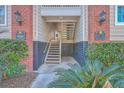 Entrance to apartment building with stairs, brick facade, and lush greenery at 1600 Long Grove Dr # 914, Mount Pleasant, SC 29466