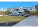 Picturesque light blue home with a concrete driveway and a landscaped yard at 2054 Briar Bend Rd, Ridgeville, SC 29472