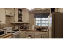 Kitchen with white cabinets, essential appliances, and a window view at 141 Wintergreen Rd, Walterboro, SC 29488