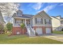 Inviting two-story home with a brick facade, double garage, and green lawn at 359 Clayton Dr, Charleston, SC 29414