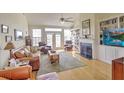 Cozy living room with hardwood floors, fireplace, built-in bookshelves, and large windows at 359 Clayton Dr, Charleston, SC 29414