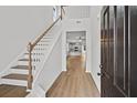Foyer with hardwood floors, staircase with white railing, view into living room and kitchen at 771 Opal Wing St, Moncks Corner, SC 29461