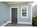 Side exterior view showcasing the home's light green siding and gray door at 773 Opal Wing St, Moncks Corner, SC 29461