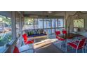 Relaxing screened porch with swing, table, chairs, and beachy decor at 900 Fairway Dr, Edisto Island, SC 29438