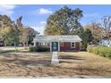 Quaint brick home with a teal front door and a manicured lawn at 1001 Lango Ave, Charleston, SC 29407