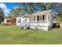 Charming white home with covered front porch and lush green lawn at 2754 Houston St, North Charleston, SC 29405