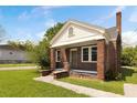 Charming red brick home with white trim, covered porch and lush green lawn at 1808 Calvert St, North Charleston, SC 29405
