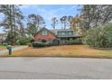 Two-story brick home with a green metal roof, driveway, and attached garage at 202 Telfair Ct, Summerville, SC 29485