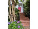 Red front door with brick steps and blooming hydrangeas at 208 Sumter Ave, Summerville, SC 29483