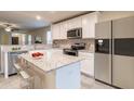 Modern kitchen with white cabinets, granite island, and stainless steel appliances at 749 Meadowbrook Ln, Summerville, SC 29486