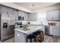 Modern kitchen with gray cabinets, granite island, and stainless steel appliances at 764 Meadowbrook Ln, Summerville, SC 29486