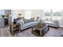 Spacious living room with gray sofa, wooden coffee table, and large windows at 764 Meadowbrook Ln, Summerville, SC 29486
