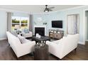 Cozy living room with fireplace, light colored sofas, and hardwood floors at 147 Royal Cainhoy Way, Huger, SC 29450