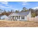 Gray house with rocking chairs on the front porch, next to another house at 255 S Railroad Avenue, Ridgeville, SC 29472