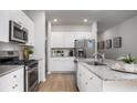 Modern kitchen with white cabinets, granite countertops, and stainless steel appliances at 304 Tiliwa Street, Summerville, SC 29486