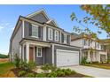 Two-story gray house with white garage door and landscaping at 318 Abercom Place Dr, Moncks Corner, SC 29461