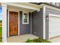 Dark wood front door with sidelight and gray siding at 318 Abercom Place Dr, Moncks Corner, SC 29461