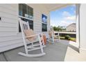 Relaxing front porch with two white rocking chairs and decorative pillows at 437 Parish Farms Dr, Summerville, SC 29486