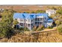 House with a blue roof, screened porch, and water views at 8 Seagrass Ln, Isle of Palms, SC 29451