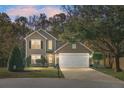 Two-story house with a white garage door and a landscaped lawn at night at 102 Teakwood Ct, Summerville, SC 29485