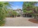 Two-story home with gray siding, gravel driveway, and carport at 2264 Seascape Ct, Seabrook Island, SC 29455