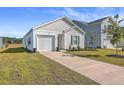 Newly built home with a white exterior, landscaped lawn, and driveway at 120 Clear Tide Dr, Summerville, SC 29486