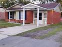 Brick ranch home with covered entry and landscaped lawn at 7660 Crossgate Blvd, North Charleston, SC 29420