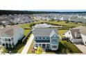 Aerial view of a teal house and neighborhood pond at 215 Brightside Trl, Summerville, SC 29483