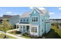 Two-story light teal house, gray roof, white accents, side yard view at 215 Brightside Trl, Summerville, SC 29483