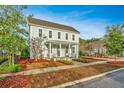 Two-story light green house with a front porch and well-maintained lawn at 248 Great Lawn Dr, Summerville, SC 29486