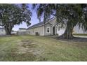 Side view of a tan house with mature oak trees and a fenced yard at 435 Eva St, Moncks Corner, SC 29461