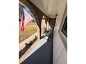 Covered porch with rocking chairs, brick columns, and American flag at 141 Tall Pines Rd, Ladson, SC 29456