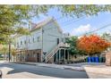 Renovated light green house with a side yard and stairs leading to a porch at 132 Spring St, Charleston, SC 29403