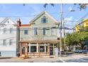 Renovated light green house with large windows and brick base at 132 Spring St, Charleston, SC 29403