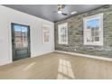 Modern bedroom with dark door, brick accent wall, and hardwood floors at 194 Nassau St, Charleston, SC 29403