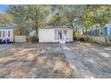Charming white house with front porch and walkway, surrounded by trees at 2208 Bailey Dr, North Charleston, SC 29405