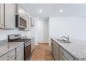 Modern kitchen with gray cabinets, granite counters, and stainless steel appliances at 252 Watersglen Way, Summerville, SC 29486