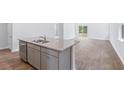 Modern kitchen island with granite countertop and stainless steel sink at 252 Watersglen Way, Summerville, SC 29486