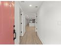 Bright entryway with coral door and view into the open concept living area and kitchen at 31 Allway St, Charleston, SC 29403
